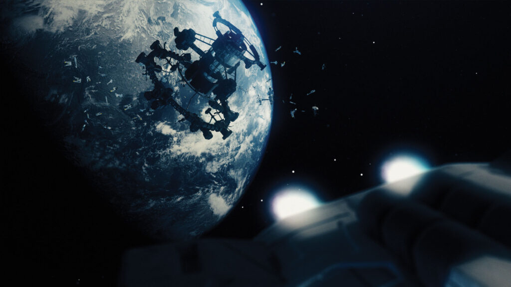 A screen capture from The Last Ark game by Terabbit Studios, featuring a view of Earth from orbit. The Earth looks cold and uninviting. Orbiting around the Earth is an orbital station surrounded by dozens of abandoned transport craft. The camera is attached to the base of one of the arks as it departs earth, with the rocket booster out of focus in the foreground.